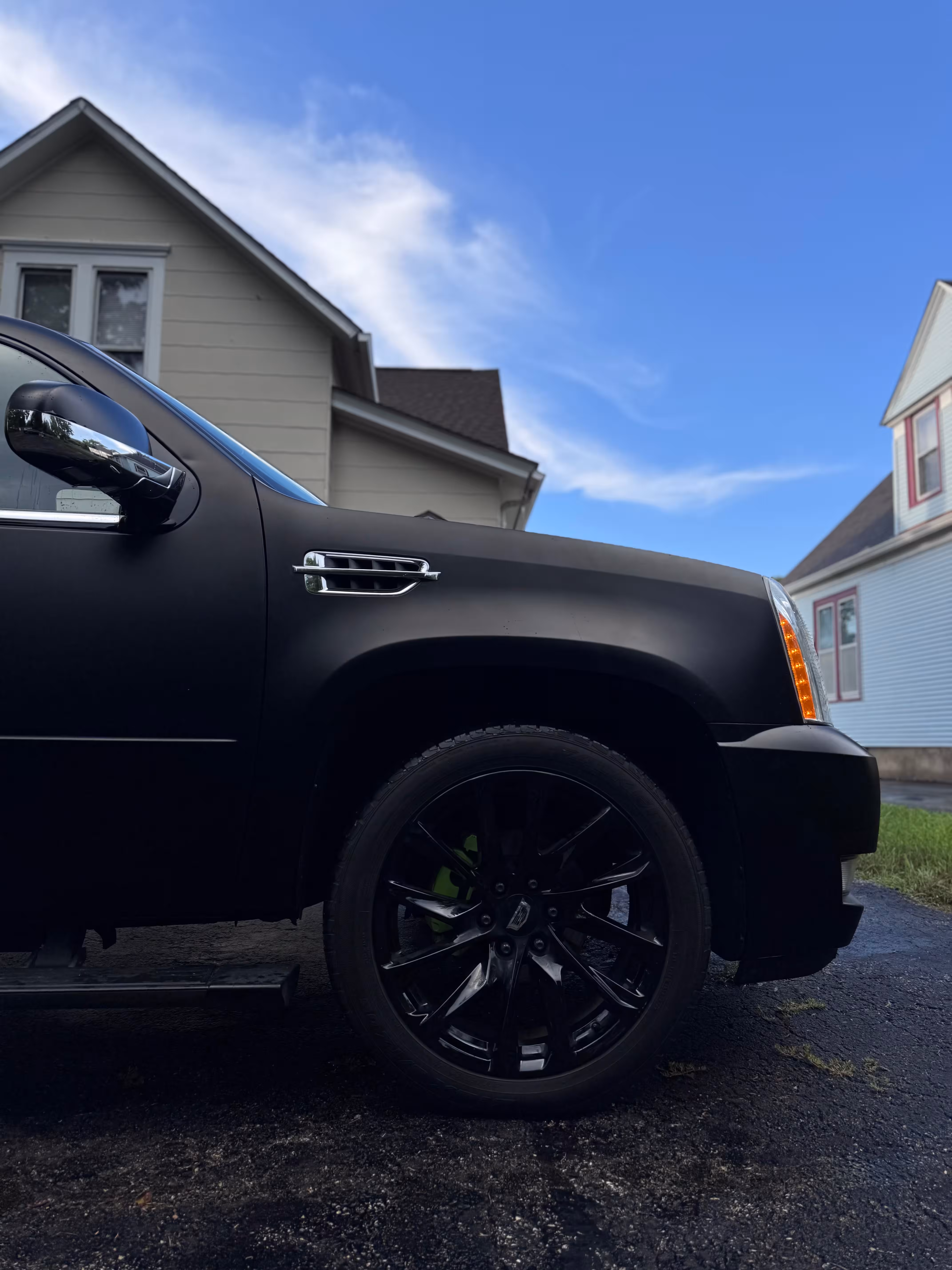 Matte black Cadillac wrap — side and wheel view